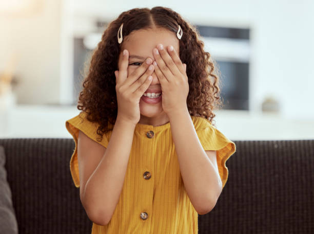 Adorable little mixed race child covering face with hands and peeking. One small cute hispanic girl sitting alone on living room sofa and playing hide and seek. Smiling playful kid with curly hair Adorable little mixed race child covering face with hands and peeking. One small cute hispanic girl sitting alone on living room sofa and playing hide and seek. Smiling playful kid with curly hair 9 stock pictures, royalty-free photos & images