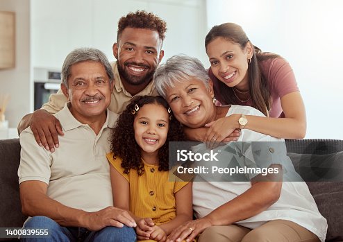 istock Portrait of mixed race family with child enjoying weekend in living room at home. Adorable smiling hispanic girl bonding with grandparents, mother and father. Happy couples and child sitting together 1400839555