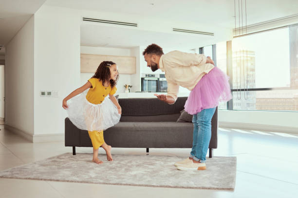 Full length mixed race single father dancing with adorable daughter in living room at home. Cute little hispanic girl wearing tutus with single parent and bonding in lounge. Man and child together Full length mixed race single father dancing with adorable daughter in living room at home. Cute little hispanic girl wearing tutus with single parent and bonding in lounge. Man and child together curtseying stock pictures, royalty-free photos & images