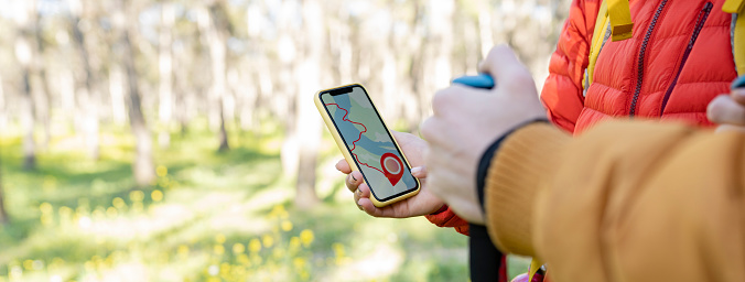 group of people in the forest consulting a map on a gps smartphone