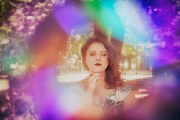 Young woman portrait posing with eyes closed in rainbow frame
