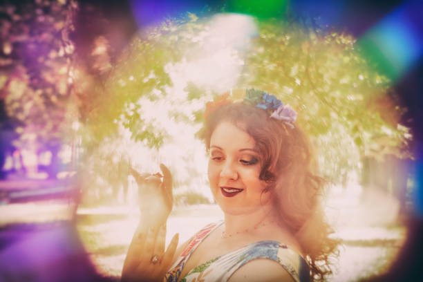 Young woman headshot portrait in rainbow frame, looking down and smiling while dancing