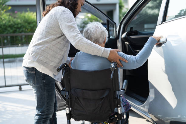 Asian senior or elderly old lady woman patient sitting on wheelchair prepare get to her car, healthy strong medical concept. stock photo