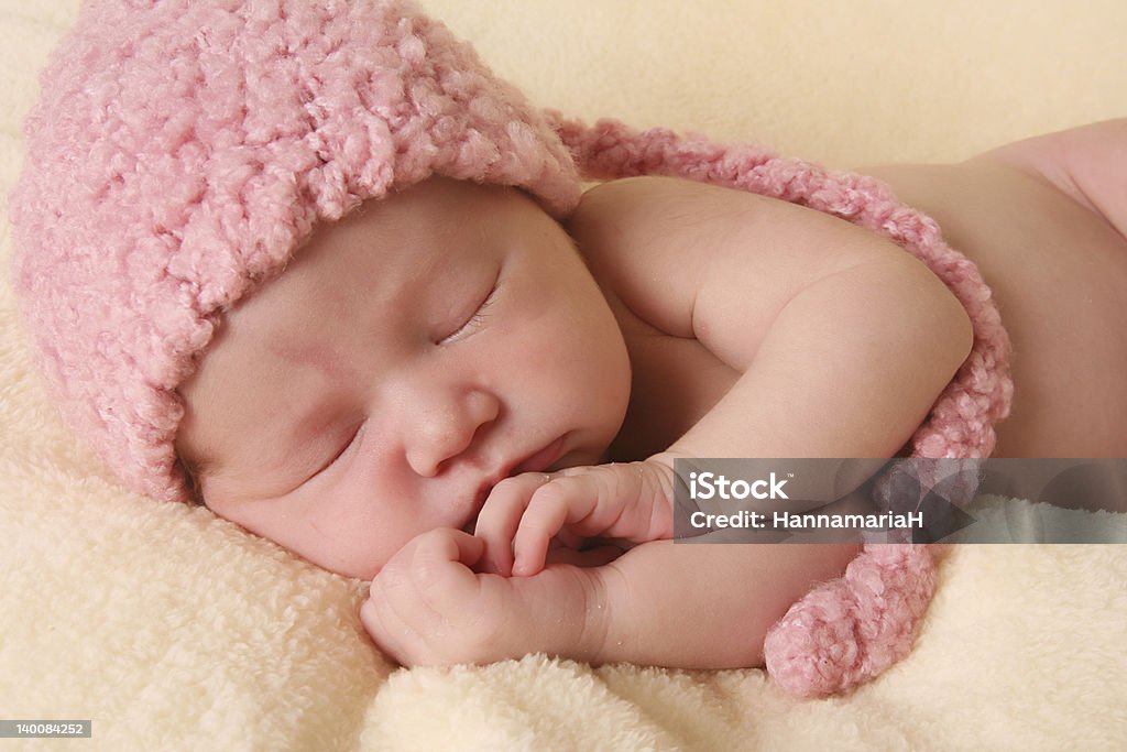 A photograph of a newborn baby Newborn baby girl wearing a pink knitted elf hat. 0-11 Months Stock Photo
