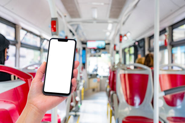 istock Hand holding blank screen mobile phone in blurred public bus 1400842651