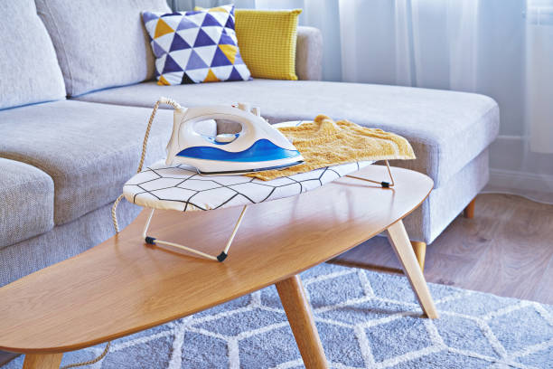 istock Iron for ironing on small tabletop ironing board in cozy and living room 1400844924