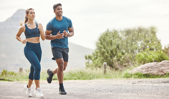 istock Fit young man and woman running together outdoors. Interracial couple and motivated athletes doing cardio workout while exercising for better health and fitness at the park 1400845838