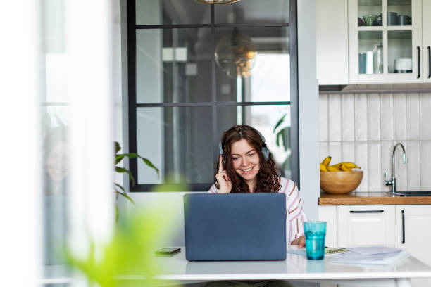 istock Young woman working from home sitting at the kitchen with laptop 1400846048