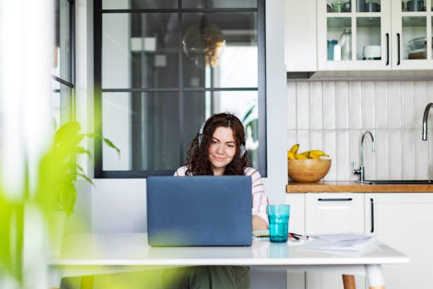 istock Young woman working from home sitting at the kitchen with laptop 1400846112