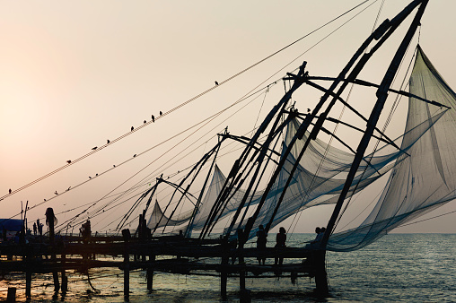 Chinese fishing nets at rest over the Arabian Sea at sunset on a fine autumn evening in Forth Kochi, Kerala, India.