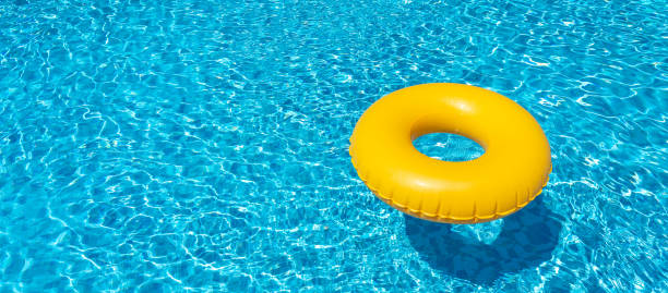 istock Yellow inflatable ring floating in swimming pool. Vacation concept with copy space 1400850748
