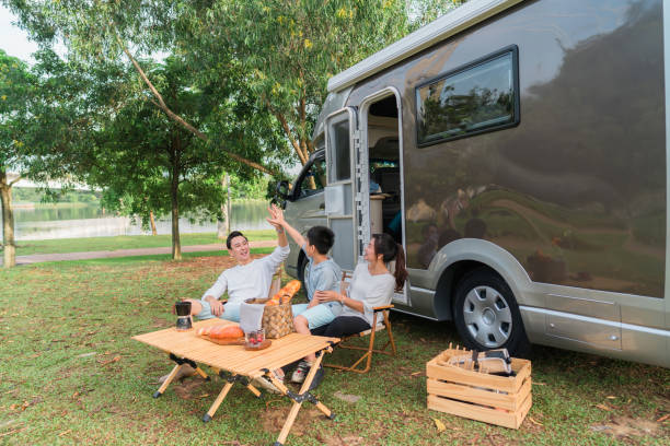 Family high five in front of motor home holidays stock photo