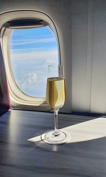 coupe de champagne près de la fenêtre de l’avion - water jet photos et images de collection