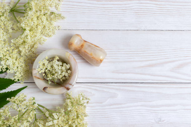 Mortar and pestle with elder flowers. stock photo