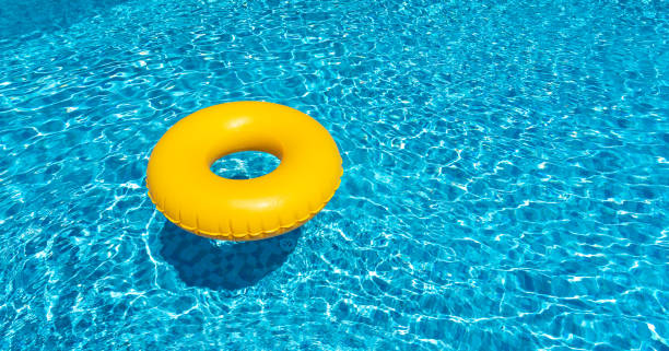 青いプールに浮かぶ黄色のリング。インフレータブルリング、レストコンセプト - 浮き輪 ストックフォトと画像