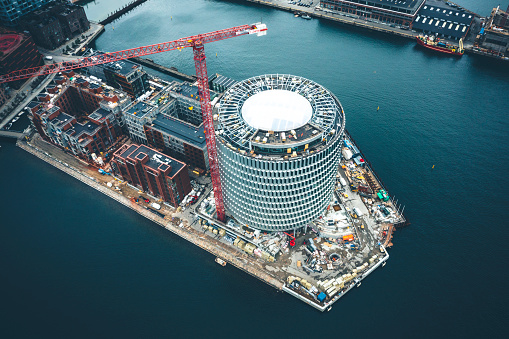 Cityscape with construction of contemporary office buildings and residential flats at the up class oceanfront at Nordhavn in Copenhagen, Denmark, shot with drone. Here the area Nordø, a little island  is under development by use of cranes.