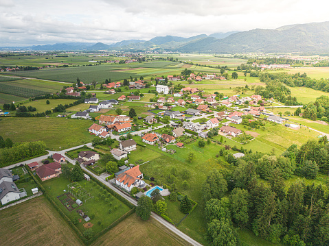 Warm sunset light illuminating the picturesque patchwork quilt landscape of green pasture, agricultural crops, farms and villages below clear blue panoramic skies.