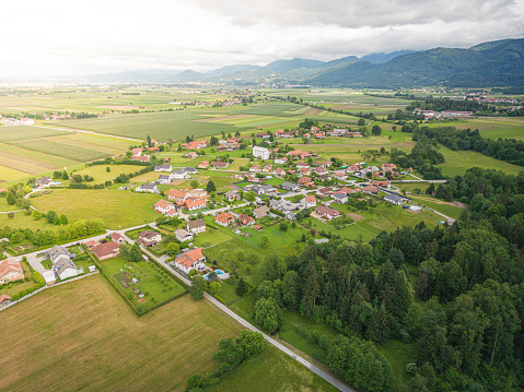 Warm sunset light illuminating the picturesque patchwork quilt landscape of green pasture, agricultural crops, farms and villages below clear blue panoramic skies.