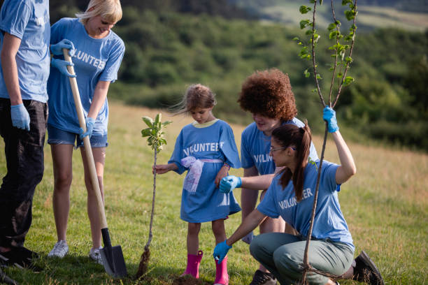 istock A small group of environmentalists planting a tree in the meadow. 1400856947