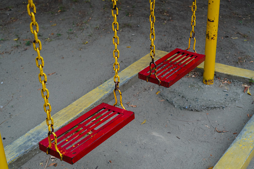 two of red chain swings on modern kids playground