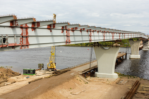 Kirishi, Russia - 24 May, 2022.\nConstruction of a road bridge in Kirishi across the Volkhov River.