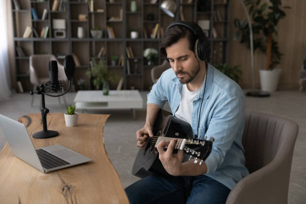 istock Young male musician learning to play guitar at web course 1400865204