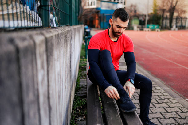 istock Man tying his shoelace outdoors 1400865512