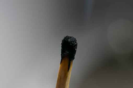 Hand holding a burning match, isolated on black background