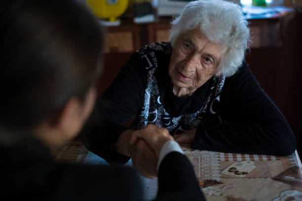 During their walk in the evening, the senior adult grandmother pauses to adjust her preteen grandson's glasses.