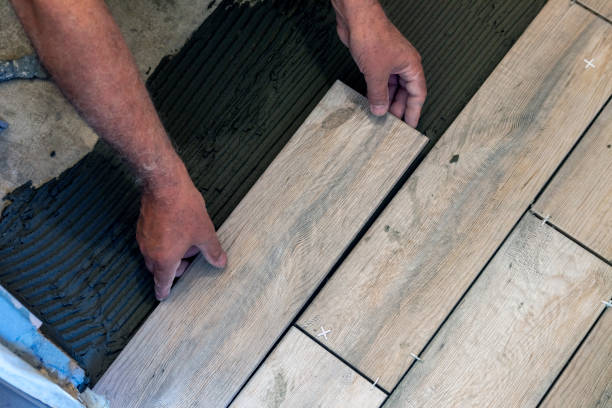 istock Wood tile flooring. A worker lays floor tiles. 1400870171