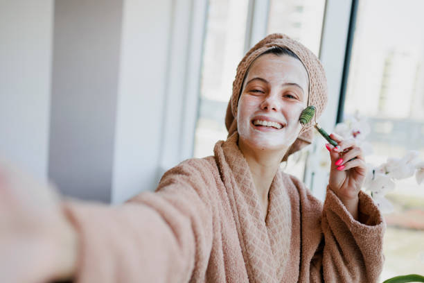 istock Woman using jade roller on her face at home. Young girl massaging face by jade roller. Self-care facial massage, anti-aging lifting skincare procedure 1400871205