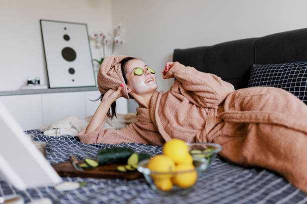 portrait d’une femme ayant une routine de soins de la peau au lit - cucumber facial mask human face women photos et images de collection