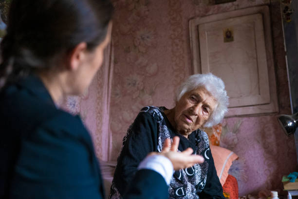 Female broker offering different insurance plans to a senior woman in her home.