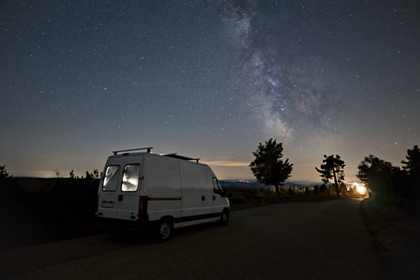 istock Milky Way over illuminated camper van and silhouette of trees, Black Forest, Germany 1400873323
