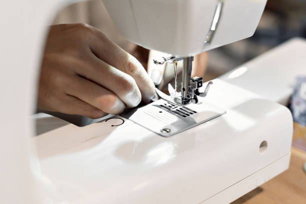 istock Close-up of a seamstress threading a sewing machine needle. 1400879660