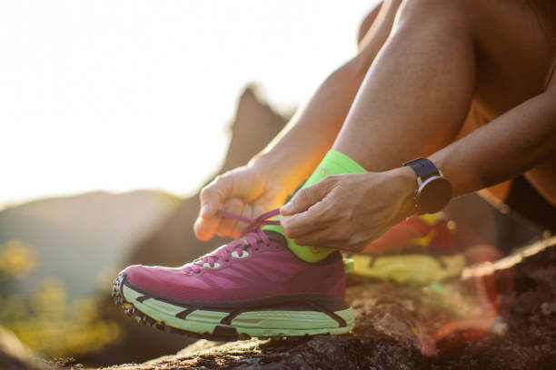 istock Woman tying shoe lace before running training on mountain 1400880209