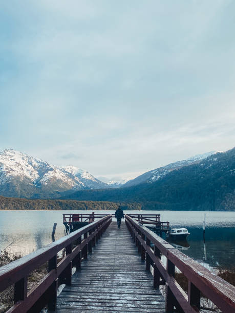 istock Man walks on a over a lake towards the mountains 1400881308