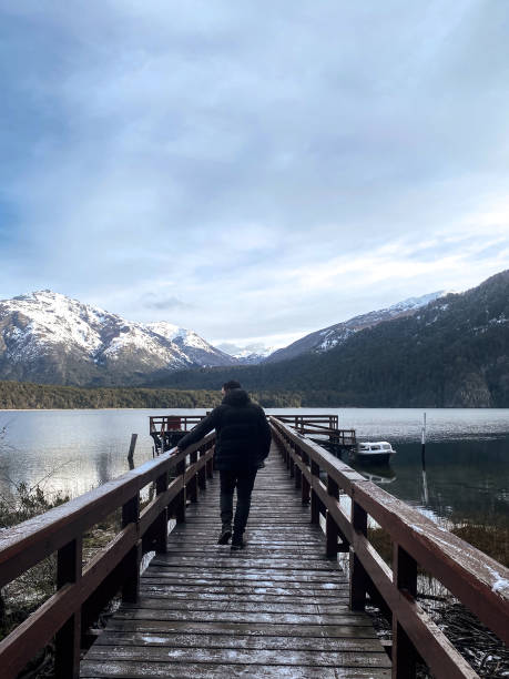 istock Man walks on a over a lake towards the mountains 1400881451