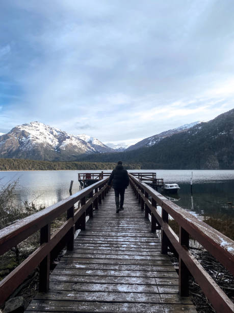 istock Man walks on a over a lake towards the mountains 1400881459
