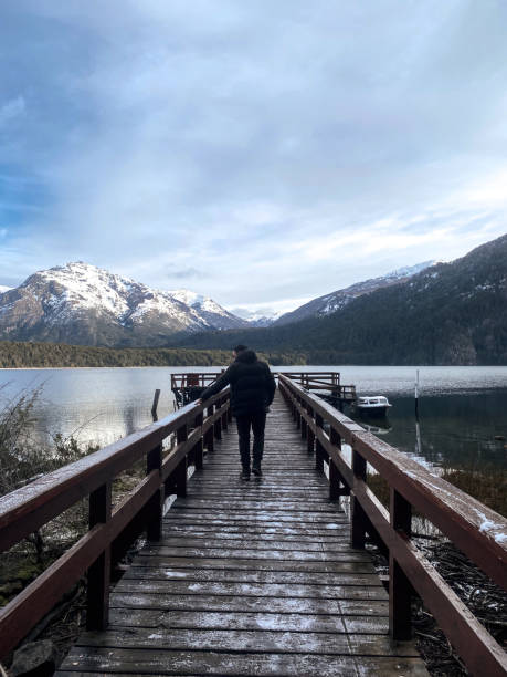 istock Man walks on a over a lake towards the mountains 1400881548