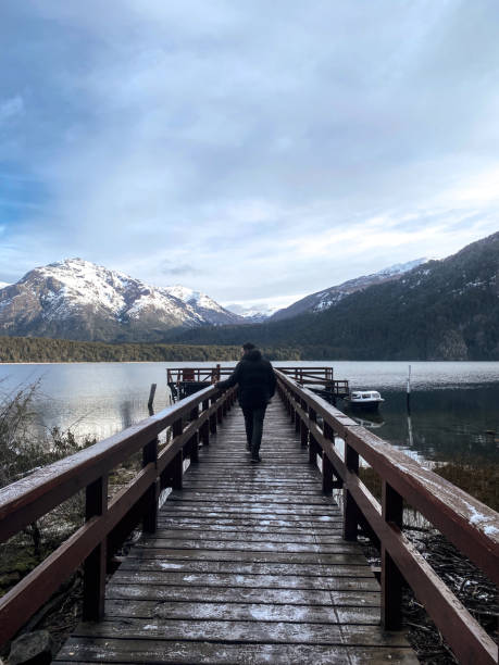 istock Man walks on a over a lake towards the mountains 1400882082