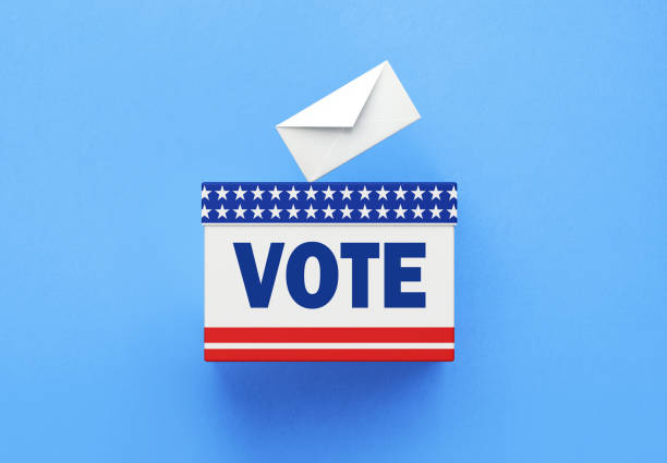 Vote written ballot box and white vote envelope sitting on white background. Horizontal composition with copy space. 2022 USA Midterm Election concept.