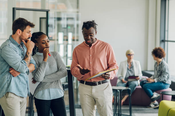 istock Multiracial business colleagues discussing about documents in the office 1400882218