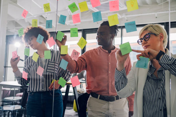 istock Multiracial team at work writing ideas on sticky notes on the glass wall 1400882221
