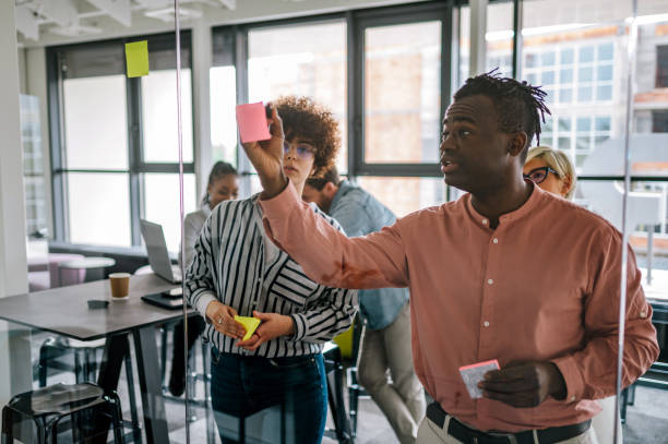 istock Multiracial team at work writing ideas on sticky notes on the glass wall 1400882222
