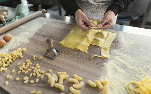 Close up female hands preparing fresh homemade ravioli pasta