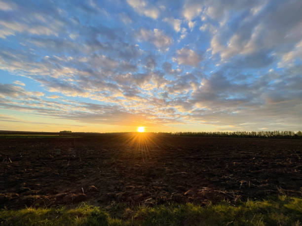 istock Dramatic sunset sky with clouds. Spectacular sunset over the field 1400884057