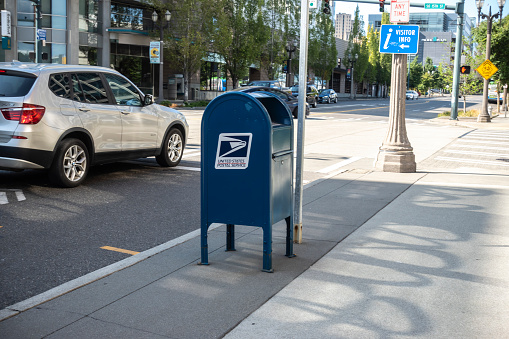 Tacoma, WA USA - circa August 2021: Street view of a United States Postal service blue mailbox in downtown Tacoma.
