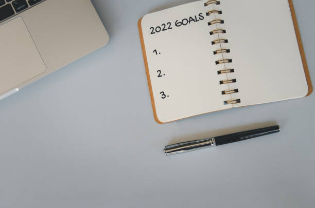istock 2022 goal notebook and pen on background. Top view copy space. 1400893783