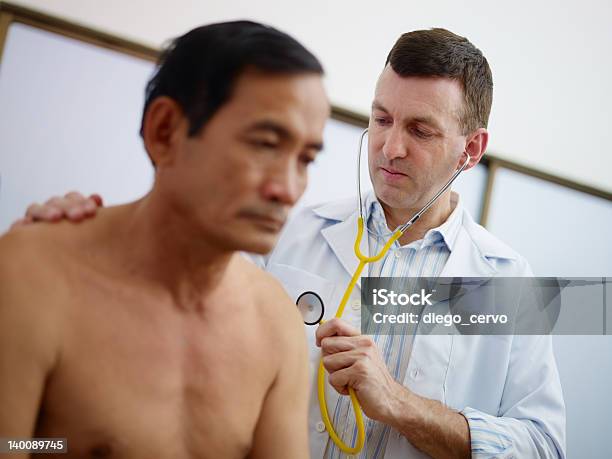 Doctor Working And Visiting Old Man In Clinic Stock Photo - Download Image Now - Doctor, Doctor's Office, Listening